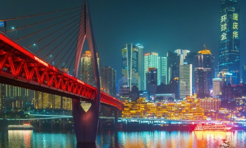 Chongqing skyline at night with illuminated red bridge reflecting in water, representing China's digital business transformation