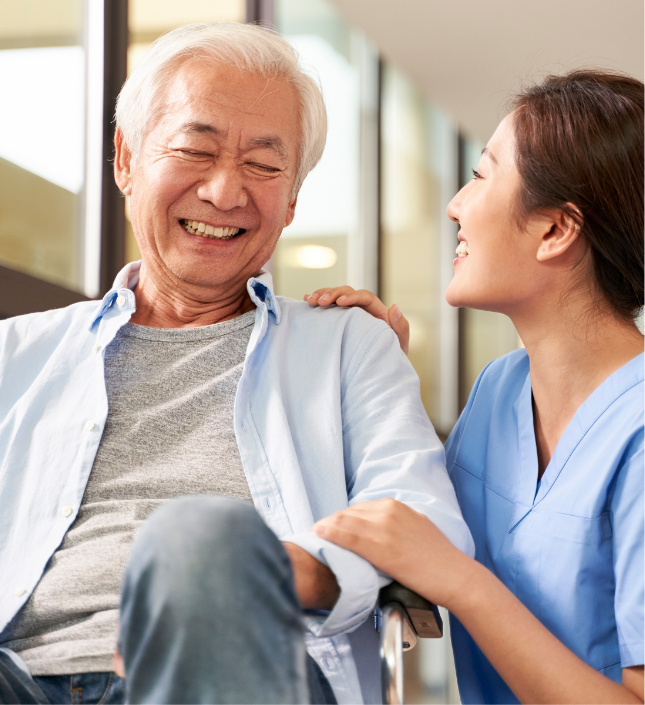Senior man and healthcare professional in blue scrubs smiling together in a medical facility setting