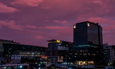 Pune skyline at dusk with illuminated buildings against a purple twilight sky