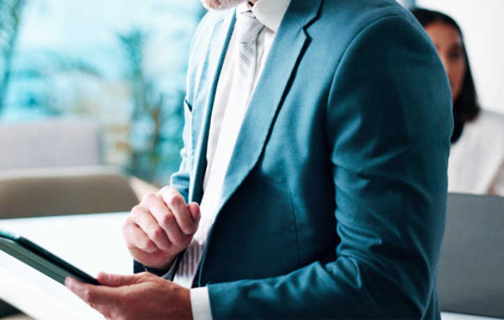 Professional man in teal blazer reviewing document in modern office setting